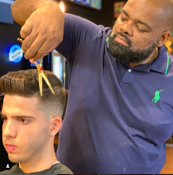 Andre cortando o cabelo de um cliente